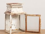 une petite lanterne blanche posée sur une table en bois