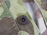 a close up of a button on a camouflage shirt