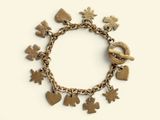a gold bracelet with charms on it on a white surface