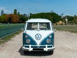 a white and blue vw bus parked on the side of the road