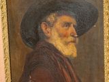 portrait d'un vieil homme portant un chapeau noir et une robe rouge