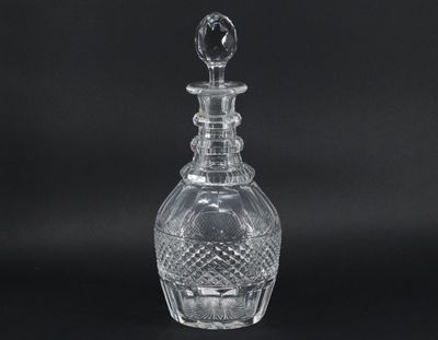 a clear glass bottle with a stopper on a black background