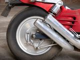a close up of a red motorcycle parked in a garage