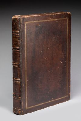 un vieux livre à la couverture brune posé sur une table