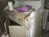 un tas de bric-à-brac dans une pièce où se trouvent un bureau et une chaise