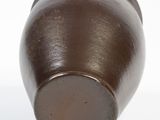 a brown vase on a white surface with a white background