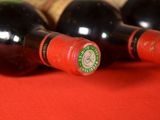 several bottles of wine are lined up on a red cloth
