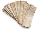 several old papers are stacked on top of each other on a white surface