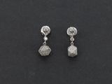 une paire de boucles d'oreilles en diamant sur une surface noire