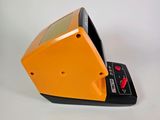an orange and black electronic device sitting on a white surface