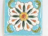 decorative tile with a flower design on a blue background