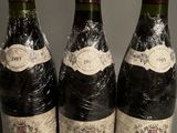three bottles of wine are wrapped in plastic and sitting on a table