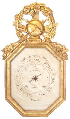 a gold clock with a clock face and a wreath around it