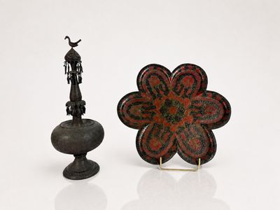 a small statue of a man standing next to a flower