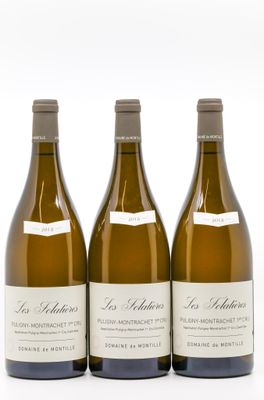 trois bouteilles de vin blanc posées l'une à côté de l'autre sur une surface blanche