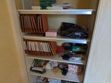 a small closet with a lot of books on the shelves
