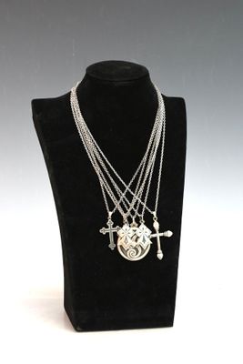 collier en argent orné d'une croix et d'un cœur, présenté sur un mannequin noir