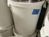 many buckets of cement sitting in the corner of a room