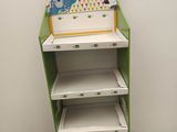 une étagère verte et blanche avec des tablettes, dans une pièce