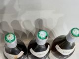 three bottles of wine are lined up on a table