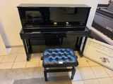a black piano and a black stool in a room