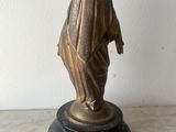 statue of a woman with a veil on her head on a marble base