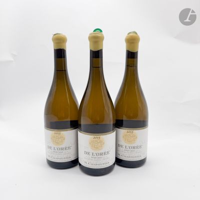 trois bouteilles de vin posées sur une table l'une à côté de l'autre