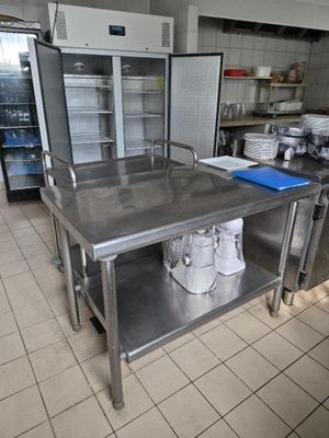 une grande table en acier inoxydable au milieu d'une cuisine