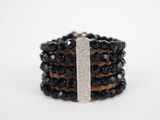 a close up of a stack of black and white bracelets