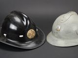 two helmets are sitting next to each other on a black surface