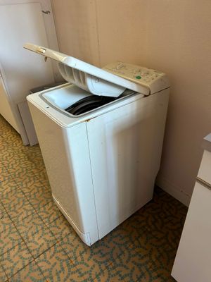 a washing machine in the corner of a kitchen