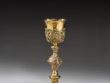 a gold plated chalicet with a floral design on the base
