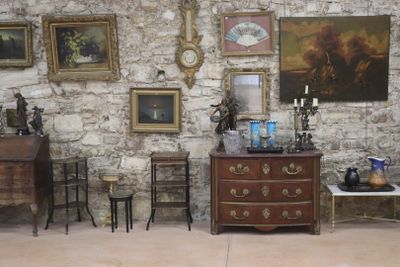 une pièce remplie de meubles anciens et de tableaux accrochés aux murs