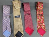 four different colored ties are lined up on a gray surface
