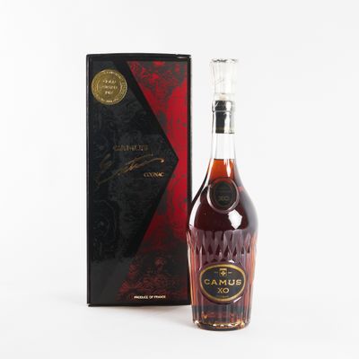 a bottle of brandy in front of a black box