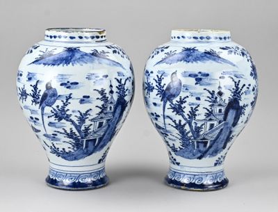 pair of blue and white vases with a landscape scene on them