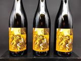 trois bouteilles de vin posées sur un bloc de bois