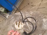 a person that is holding a power cord and plugged in a box