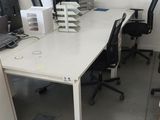 un bureau blanc sur lequel se trouvent un ordinateur portable et une imprimante