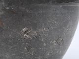 a black bowl that is sitting on a white surface