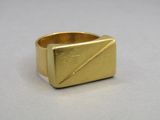 gros plan d'une bague en or sur une surface blanche