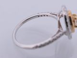 a close up of a diamond and gold ring on a white surface