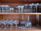 de nombreux verres et vases posés sur une étagère dans un meuble