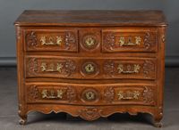 Commode à façade galbée en noyer mouluré et sculpté à décor …
