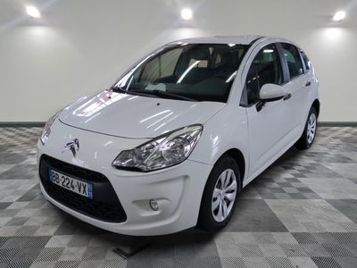la petite voiture blanche est garée sur un carrelage à carreaux