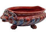 a red and blue planter with a lion head on it