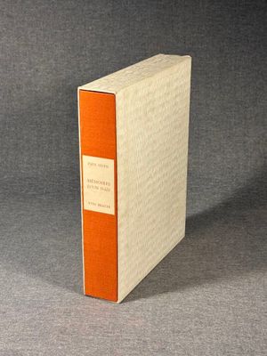 an orange and white book sitting on top of a gray surface
