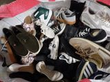 many pairs of shoes in a basket on the floor