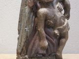 a statue of a man and a woman hugging on a tree stump