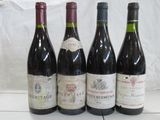 four bottles of wine are lined up on a table